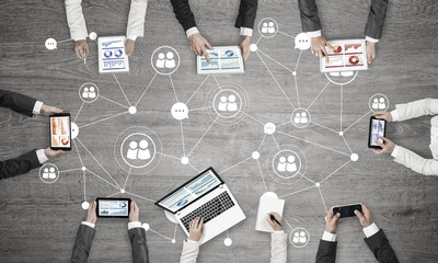 Top view of businesspeople sitting at table and using gadgets