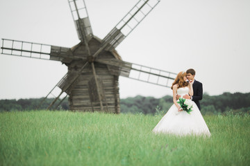 Emotional beautiful bride hugging newlywed groom at a field closeup