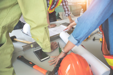 engineer people working and discussing with architecture or blueprint at construction site