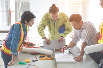 engineer people working and discussing with architecture or blueprint at construction site