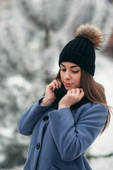 Beautiful winter portrait of young woman in the winter snowy scenery