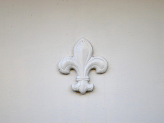white fleur de lis on a white wall © Moniek
