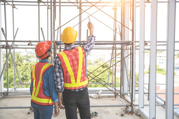 portrait engineer people looking and checking work at construction site with blueprint
