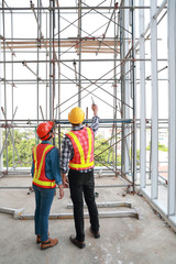 portrait engineer people looking and checking work at construction site with blueprint