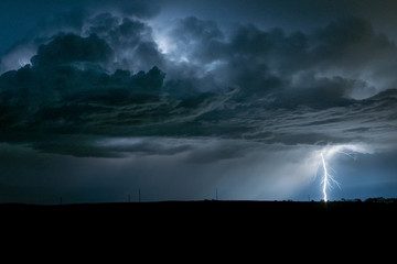 A powerful branched lightningbolt strikes down from a severe thunderstorm in Nebraska