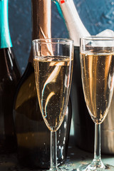 Champagne bottle in bucket with ice and glasses of champagne