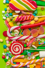 Obraz na płótnie Canvas Colorful candies on green background