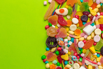 Colorful candies on green background