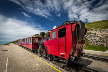 Obraz premium Red steam historic locomotive waiting in Schafbergspitze station near Salzburg, Upper Austria