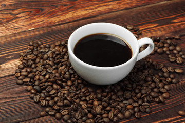 Coffee cup and coffee beans on wooden background