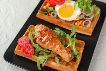 Delicious waffles with chicken drumstick and fried egg on plate, closeup