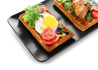 Delicious waffles with chicken drumstick and fried egg on plate, isolated on white