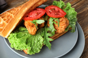 Plate with delicious waffles and chicken, closeup