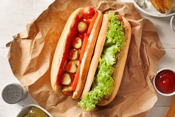 Tasty hot dogs on white table