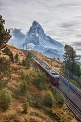 Papier Peint photo Cervin Matterhorn peak with a train against sunset in Swiss Alps, Switzerland