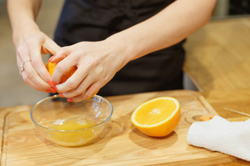 Obraz na płótnie Canvas close-up scene of squeezing oranges on kitchen selective focus