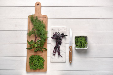 Fresh aromatic herbs on white wooden table