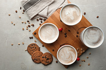 Obraz na płótnie Canvas Cups with tasty aromatic coffee and cookies on grey table