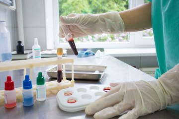 doctor determines the blood group in the treatment room on the medical table