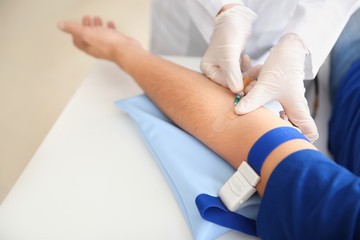 Obraz premium Female doctor preparing male donor for blood transfusion in hospital