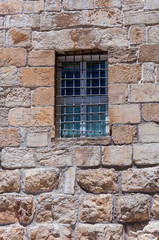 Protected bars window on the facade of an ancient building