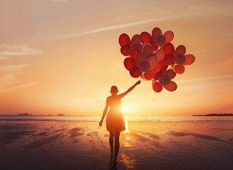 follow your dream, inspiration concept, silhouette of woman with colorful balloons on the beach - Powered by Adobe