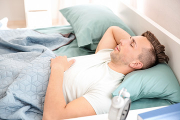 Obraz na płótnie Canvas Handsome man sleeping in bed at home