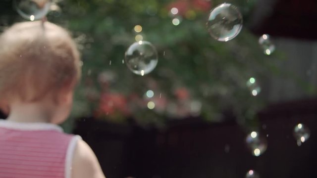 Adorable Little Girl Playing in Backyard Bubbles