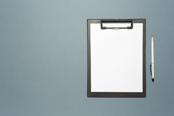 Notes clipboard with pen and blank sheets of paper as mock up copy space, top view