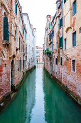 Fototapeta na wymiar Narrow water canal street in Venice Italy