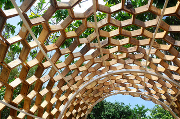 Shading walkway made of wood in the shape of a hexagon at Floria Garden in Putrajaya, Malaysia. The...
