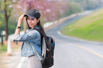 Young asian traveler with backpack looking direction on the road while traveling during holiday vacation