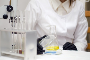 Fototapeta premium laboratory worker in a white coat working with chemicals under a microscope