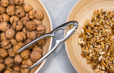 Whole walnuts, nutcracker and cracked nuts