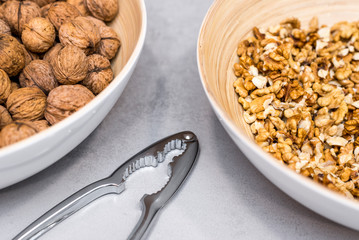 Whole walnuts, nutcracker and cracked nuts