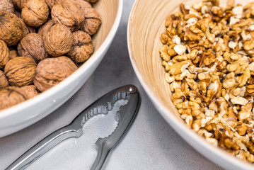 Whole walnuts, nutcracker and cracked nuts