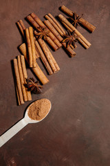 Cinnamon sticks and food, cinnamon sticks and cinnamon powder in wooden scoop. Free space for text, recipe. Ingredients for dessert