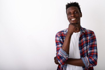 Studio shot of young happy black African man smiling while think