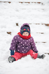 Fototapeta na wymiar Child is sitting on the snow