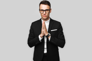 handsome young business man; male; in a classic black suit; shows poses on a gray background; Business concept; career