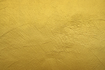 rough wall painted with gold color. textured background.
