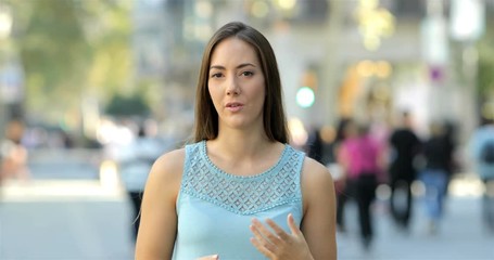 Presenter talking and looking at camera in the street