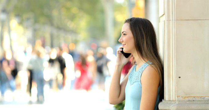 Profile Of A Girl Talking On Phone Leaning On A Wall In The Street