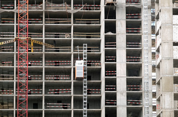Process of construction modern apartment building wall front view with machinery