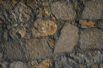 Texture background old stone wall. Wall texture of ancient old brick stone. Outdoor exterior castle facade with destroyed uneven pattern of shabby rock.