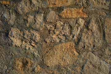 Texture background old stone wall. Wall texture of ancient old brick stone. Outdoor exterior castle facade with destroyed uneven pattern of shabby rock.