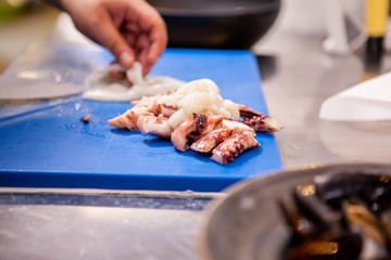 Male cook slicing seafood in restaurant kitchen.Delicious food