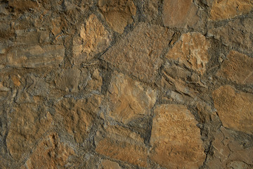 Texture background old stone wall. Wall texture of ancient old brick stone. Outdoor exterior castle facade with destroyed uneven pattern of shabby rock.