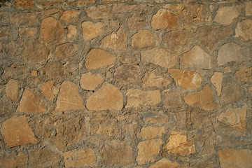 Texture background old stone wall. Wall texture of ancient old brick stone. Outdoor exterior castle facade with destroyed uneven pattern of shabby rock.