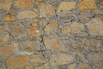 Texture background old stone wall. Wall texture of ancient old brick stone. Outdoor exterior castle facade with destroyed uneven pattern of shabby rock.